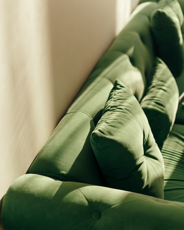 Detail eines getufteten Samtsofas in Waldgrün
